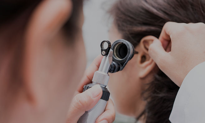 Doctor looking to a patients ear.