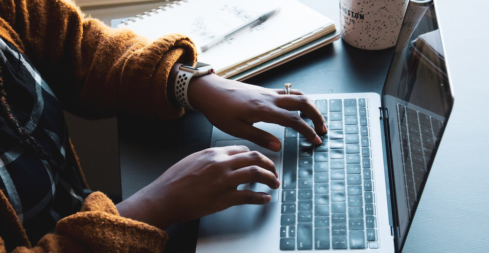 Hands typing on a computer.