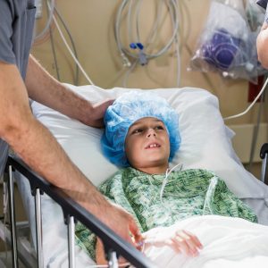 Young kid in a hospital bed getting ready for surgery.