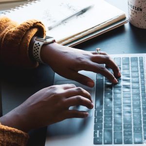 Hands typing on a computer.