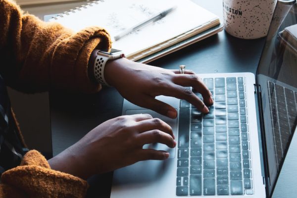 Hands typing on a computer.